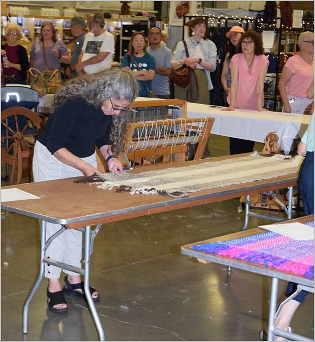 Suzie Liles judging Stranded Spinners shawl. Photo: Rich Lundquist.